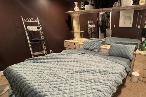 a bedroom with a bed with a blue comforter at 5 Bed House Sleeps 10 - Pool Garden Free Parking in Keansburg