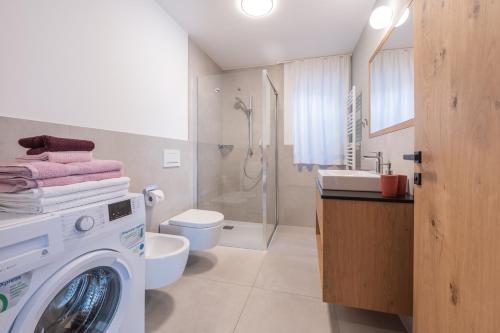 a bathroom with a washing machine and a sink at BioTop Appartement Kronplatz in Perca