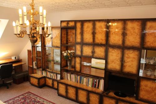 a living room with a wall of book shelves and a television at Arkady in Słupsk