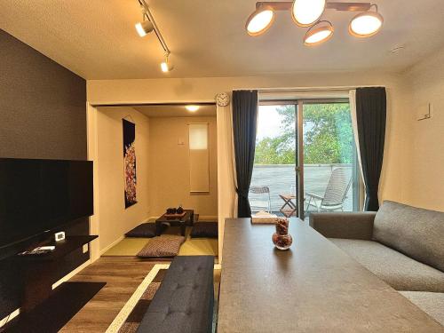 a living room with a couch and a tv at 南公園スカイビュー in Tokyo
