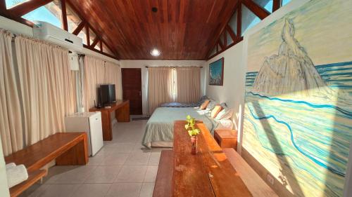 une chambre avec un lit et un tableau au mur dans l'établissement Flat Siriguela, à Fernando de Noronha