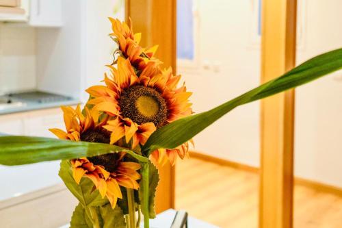 a vase filled with sunflowers sitting on a table at Gran Via Alaia Seasonal Living in Madrid