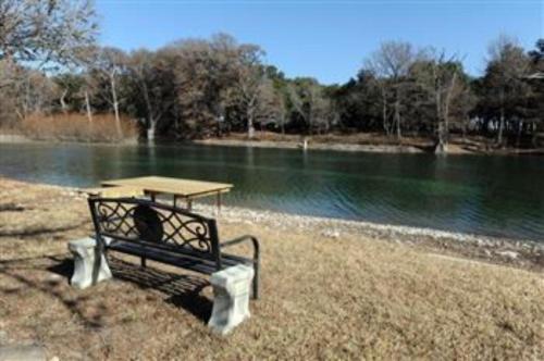a bench sitting next to a picnic table next to a river at Rock 'N Utopia in Utopia
