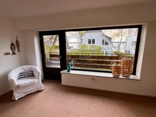 a room with a large window and a white chair at Opa Meyer in Glücksburg