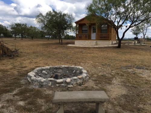 a bench in front of a building with a fire pit at Freedom River Cabin in Utopia