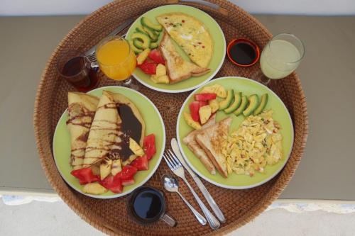 einen Tisch mit vier Speisen und Getränken in der Unterkunft The LostIsland Villas in Gili Trawangan