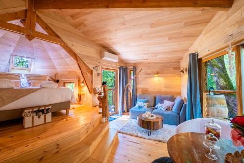 une chambre et un salon dans une cabane dans les arbres dans l'établissement Les cottages de Sarrant, à Sarrant