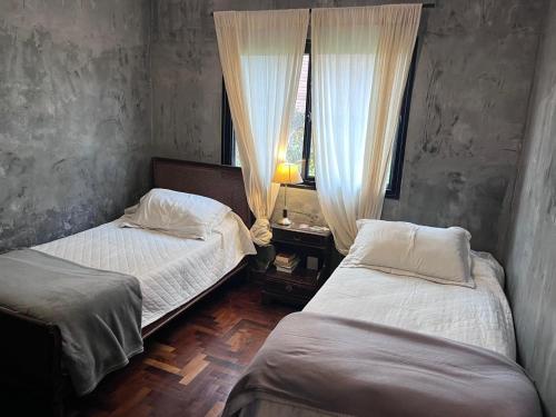 a bedroom with two beds and a window at Yerbabuena in Yerba Buena
