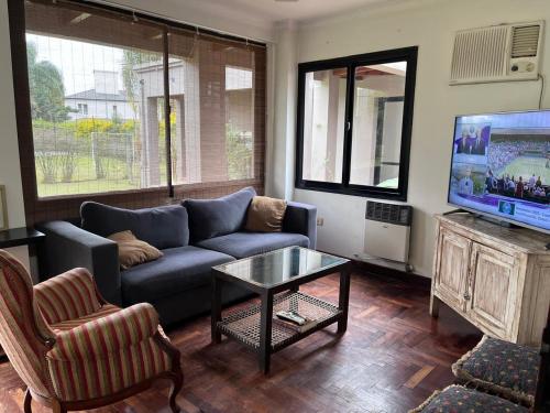 a living room with a couch and a tv at Yerbabuena in Yerba Buena