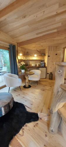 un salon avec une table et des chaises dans une cabine dans l'établissement Les cottages de Sarrant, à Sarrant
