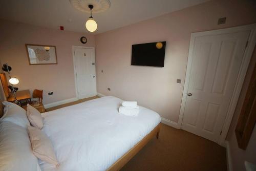 a bedroom with a white bed with a towel on it at The Alma Taverns Boutique Suites - Room 4 - Hopewell in Bristol