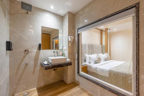 a bathroom with a bed and a shower and a sink at OPO Horizon Stanley Aerocity,Free Airport pick up or Drop in New Delhi