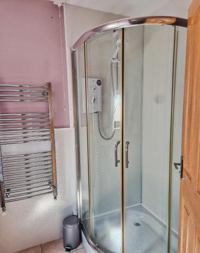 a shower with a glass enclosure in a bathroom at The Yard Bungalow in Sanquhar