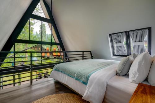 ein Schlafzimmer mit einem Bett und einem großen Fenster in der Unterkunft Intragama Villa in Puncak