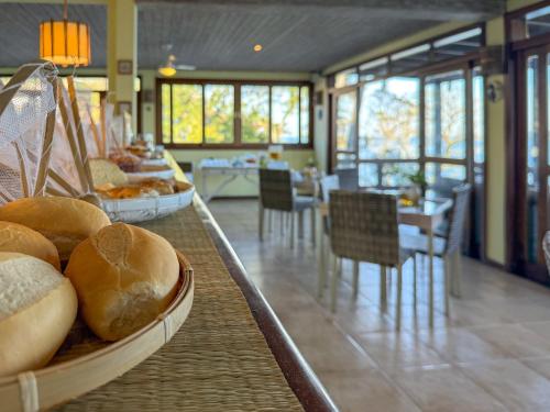een buffet met brood en een tafel met stoelen bij Pousada Fruto do Mar in Ilhabela