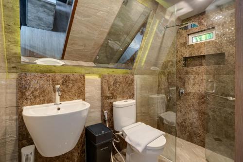 ein Badezimmer mit Toilette, Waschbecken und Dusche in der Unterkunft Intragama Villa in Puncak