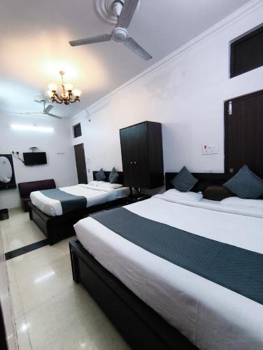a hotel room with two beds and a television at hotel blue star in Varanasi