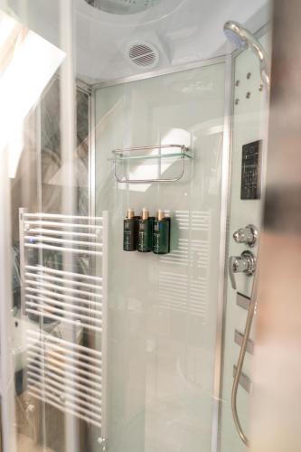 a bathroom with a shower with three bottles in it at Cabana din padure in Agapia