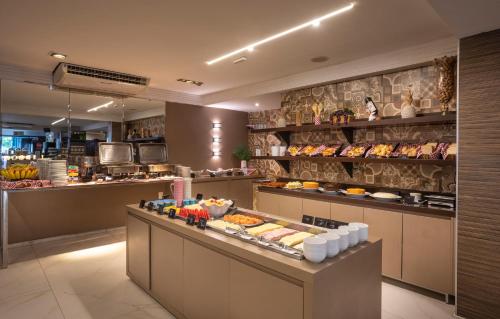 a buffet line in a restaurant with food on display at Atlântico Praia Hotel in João Pessoa