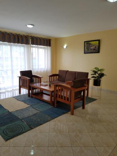 a living room with a couch and chairs in a room at Almasi airport view apartment in Syokimau