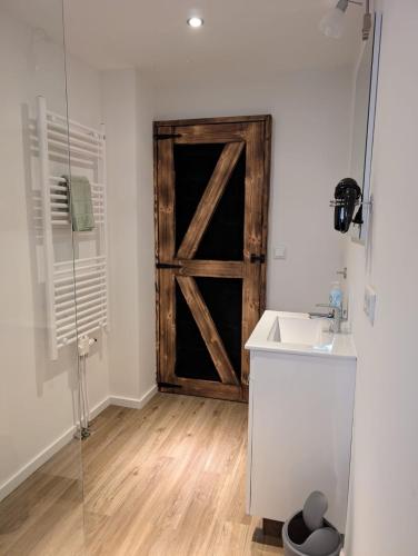 a bathroom with a sliding barn door and a sink at Stadtnah an der Förde 5502 in Flensburg