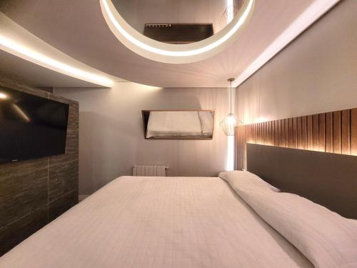 a bedroom with a large bed and a tv at Motel Daponti in Alegrete