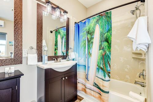 a bathroom with a sink and a shower curtain with a surfboard at Stunning Beachfront Dog Friendly Sleeps 8 in Caplen