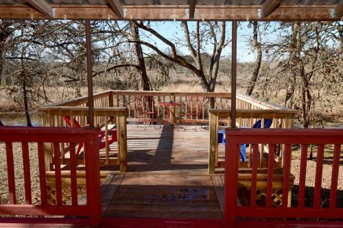 a wooden deck with two benches and a playground at Kay's River Escape in Utopia