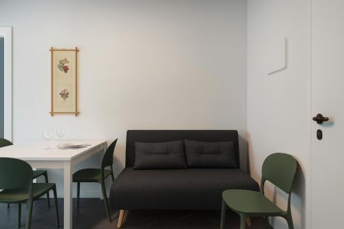 Habitación con mesa, sofá y sillas. en Ca' Mia, en Borno