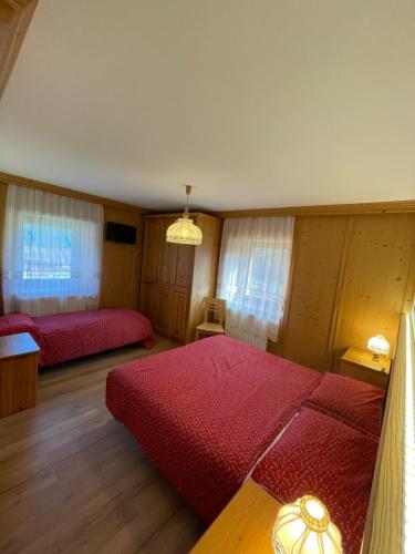 a bedroom with two beds and a chandelier at Haus Piller Cottrer Pietro in Sappada