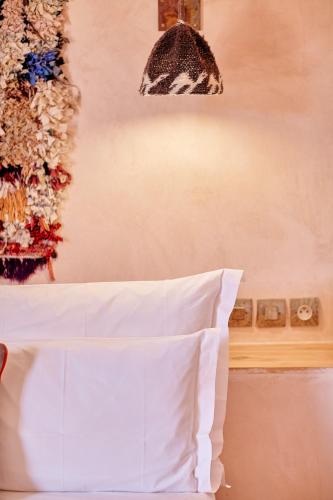 1 cama con almohada blanca en una habitación en Riad Caravane, en Aït Ben Haddou