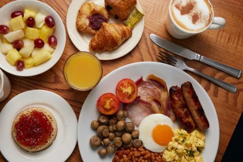 un tavolo sormontato da piatti di cibo per la colazione e caffè di Thistle London Heathrow Terminal 5 a Hillingdon