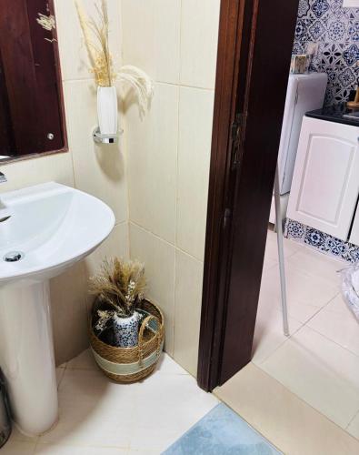 a bathroom with a sink and a toilet and a basket at Bel Air -- Sea View Studio in Ras al Khaimah