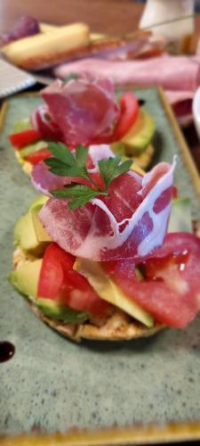 ein Sandwich mit Fleisch und Gemüse auf einem Tablett in der Unterkunft Les cottages de Sarrant in Sarrant