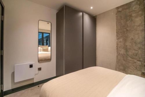 a bedroom with a bed and a mirror at Bauhaus by The Heim in Manchester