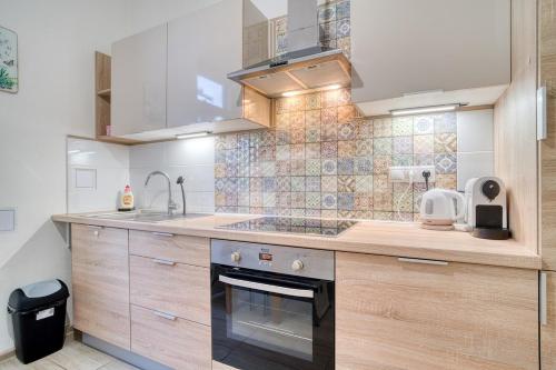 a kitchen with a sink and a stove top oven at Charming Downtown Apartment in Otilia