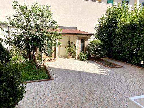 a courtyard with a building and a brick driveway at Il Giardino Segreto in Capo dʼOrlando
