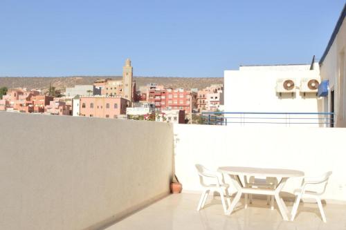 een tafel en stoelen op een balkon met uitzicht op de stad bij 1Bed Apt Sleeps 4 - Free Parking Wifi Near Beach in Tamraght Ouzdar