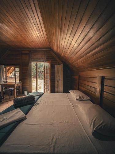 a large bed in a room with a wooden ceiling at Hotel Pousada Cata Branca in Itabirito