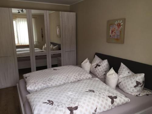 a bedroom with a bed with pillows and a mirror at Ferienhaus Wiese in Bruchhausen