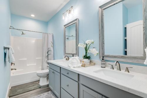 a bathroom with a sink and a toilet and a mirror at Prime Beachfront Large Deck Family Fun in Port Bolivar