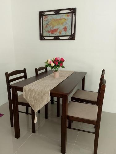 a dining room table and chairs with a vase of flowers at 2G's Staycation Home in San Felix