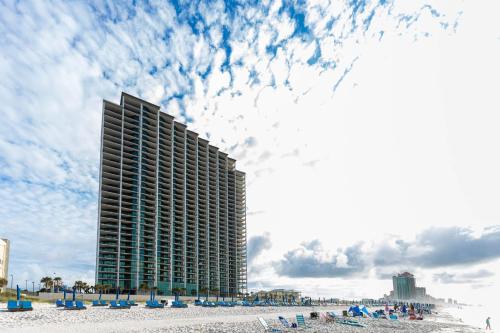 a tall building on a beach with chairs and a building at The Oasis 2209 formerly Phoenix West II 2209 condo in Romar Beach