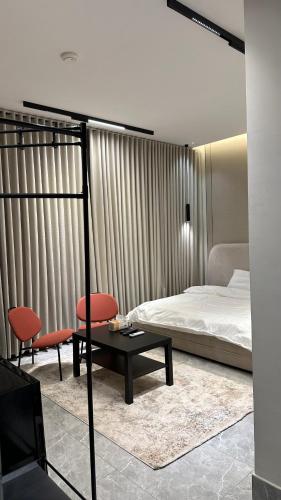 a bedroom with a bed and two chairs and a table at Vant in Riyadh