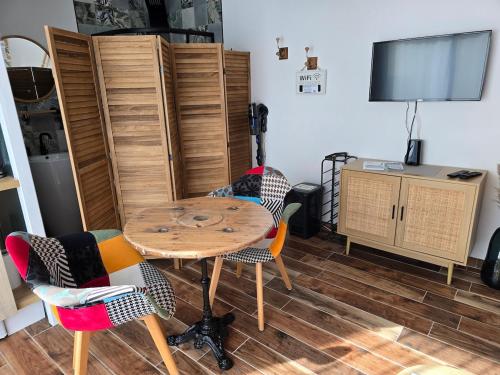 une salle à manger avec une table et des chaises en bois dans l'établissement Studio TY PASSE-TEMPS, à Saint-Pierre-Quiberon