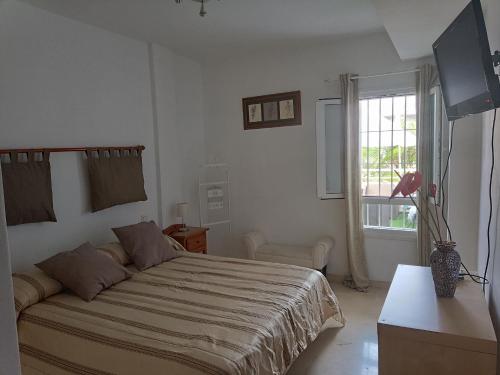 a bedroom with a large bed and a window at Apartamento Residencial mojacar in Mojácar