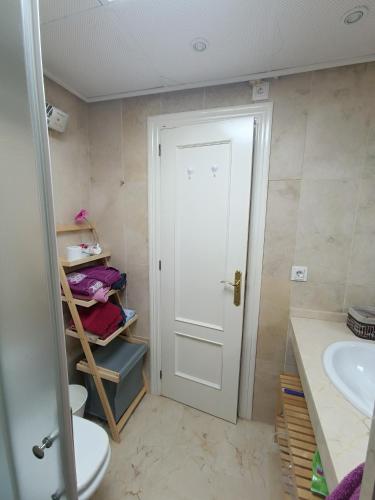 a bathroom with a toilet and a sink and a door at Apartamento Residencial mojacar in Mojácar