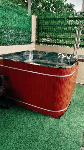 a hot tub in the middle of a patio with green grass at The G-Suite Transient House in San Felix
