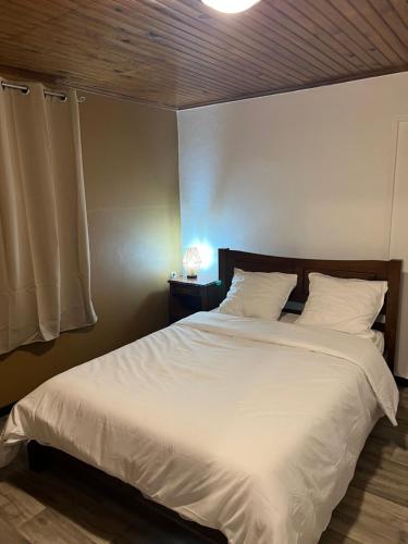 a bedroom with a large bed with white sheets and pillows at Kaz Dada in Salazie