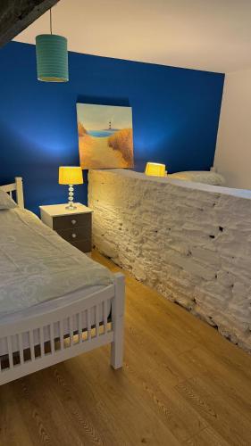 a bedroom with a large bed and a blue wall at Riverbank Apartment in Derry Londonderry